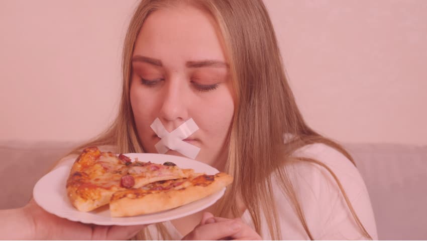 Frau mit zugeklebtem Mund blickt auf einen Teller mit zwei Pizzastücken, den ihr jemand hinhält